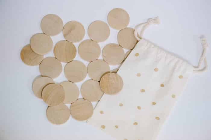 A DIY memory match game made with wooden circle discs and photos attached with Mod Podge and a small drawstring fabric bag to store it in.