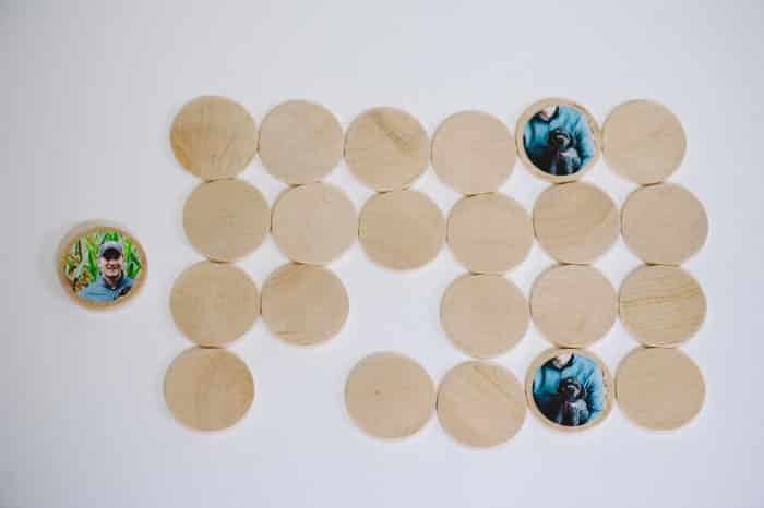 A DIY memory match game made with wooden circle discs and photos attached with Mod Podge.