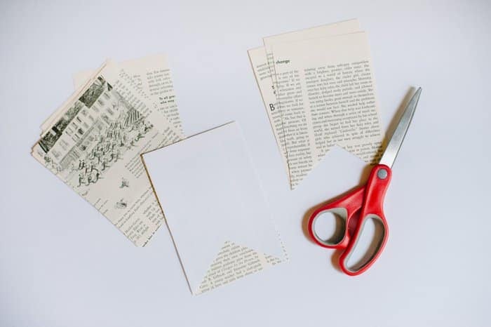 A stack of book page flags and a pair of scissors.