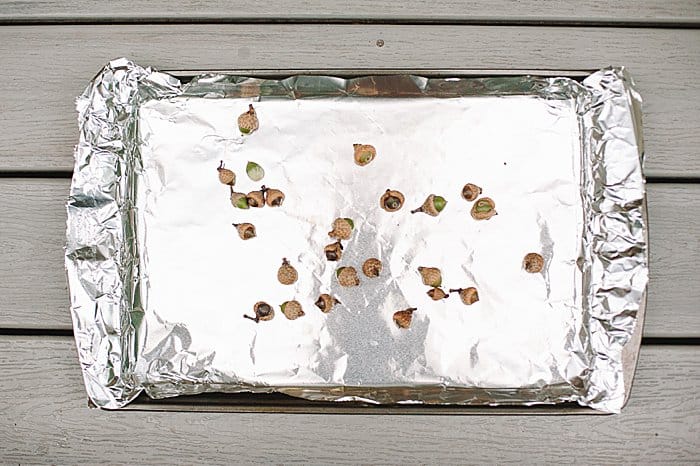 Bake acorns in oven on tin foil-lined cookie sheet