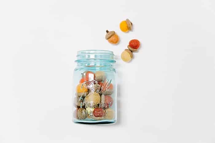 a blue mason jar is the perfect place to display felt ball acorns