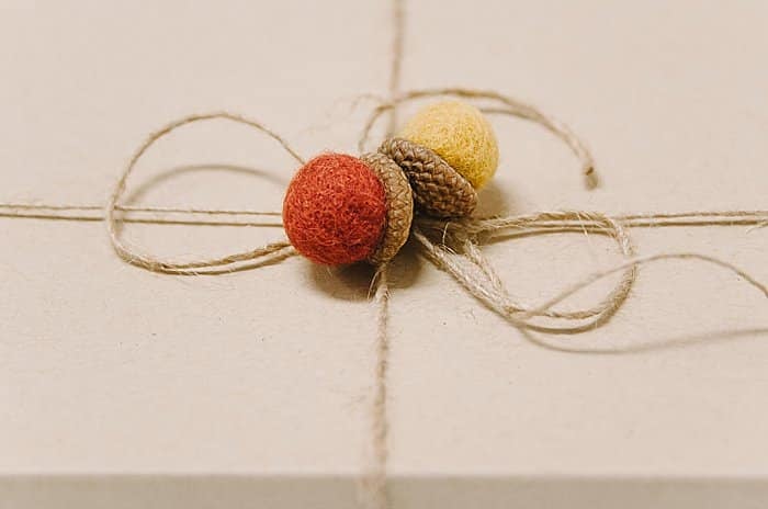 hot glue felt ball acorns onto twine when you wrap a gift