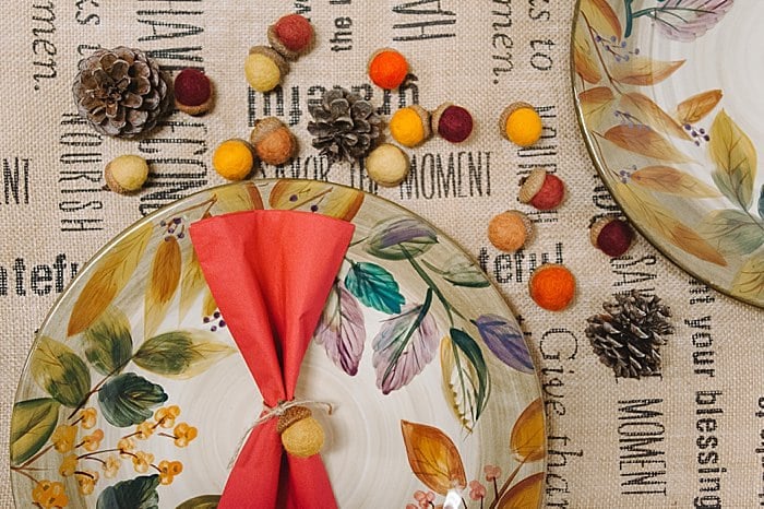 fall or thanksgiving place setting can use felt ball acorns as napkin holders and scatter felt acorns and pine cones on the table