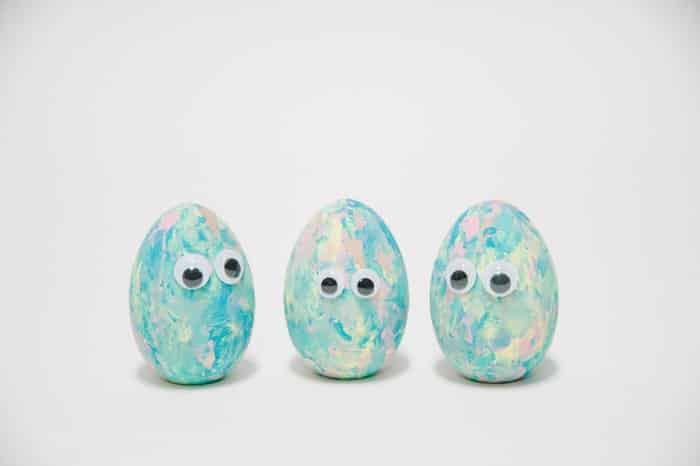 Eggs painted in pastel colors with googly eyes glued to the front of them.