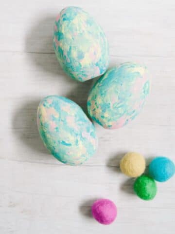 Painted wooden easter eggs in pastel colors with felt balls.