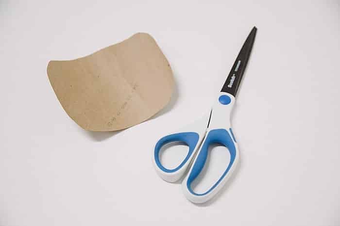 Scissors and a cardboard rectangle with the edges rounded.