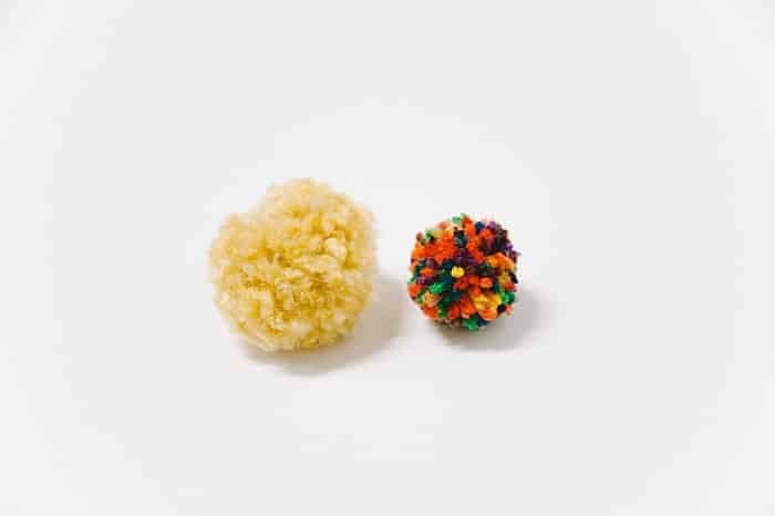 size comparison between yarn pom poms made with different kinds of yarn