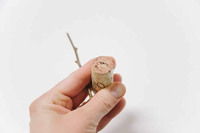 poke a hole in the wine cork and insert the stick to make the base of the pom pom tree