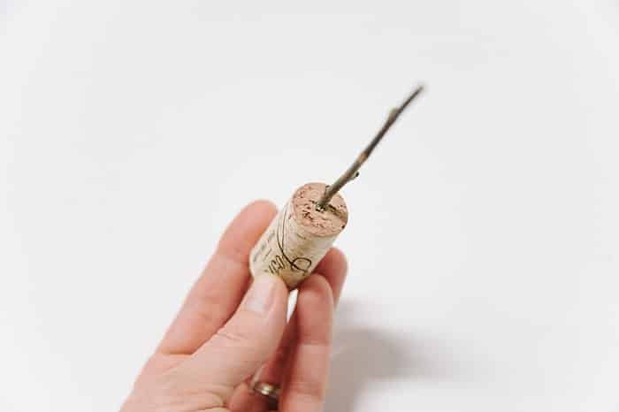 hot glue the stick into the hole in the wine cork
