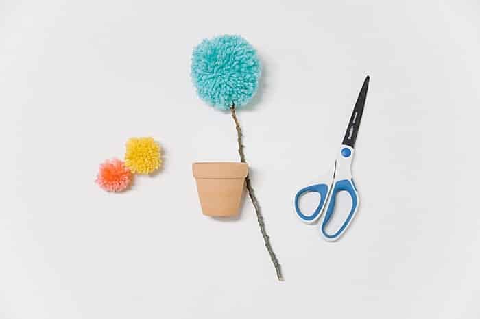 making a potted flower in a mini clay pot with a big pom pom made of yarn