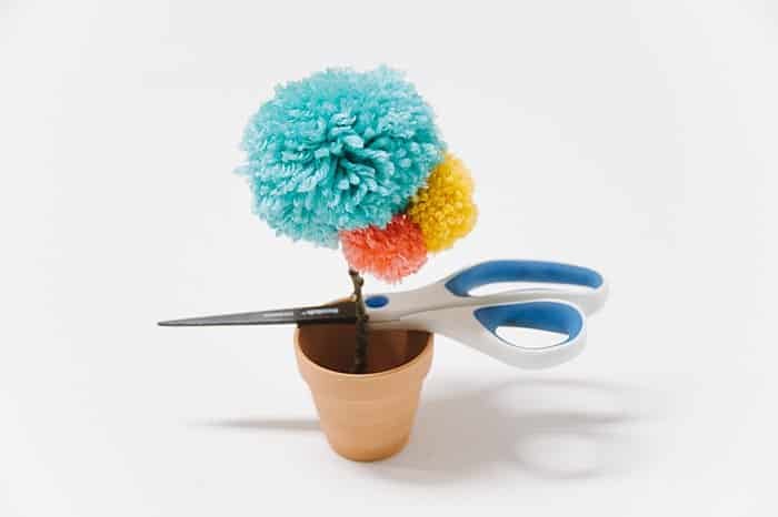 hot glue pom pom flower into clay pot and let glue dry completely