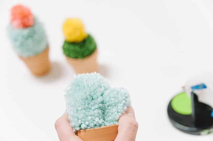Add a yarn pompom to a terracotta pot to make a cacti.