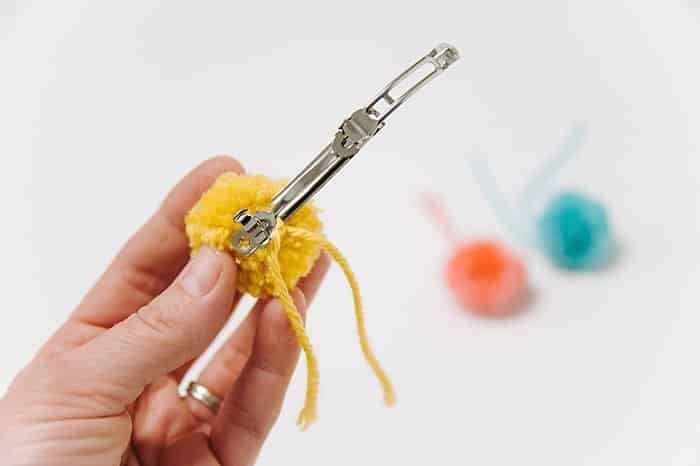 making a diy barrette with pom poms on it