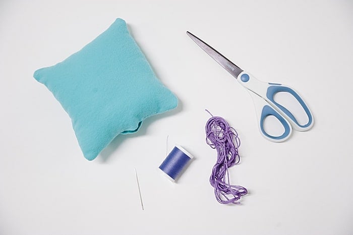 Supplies needed to close up a pillow with a ladder stitch.