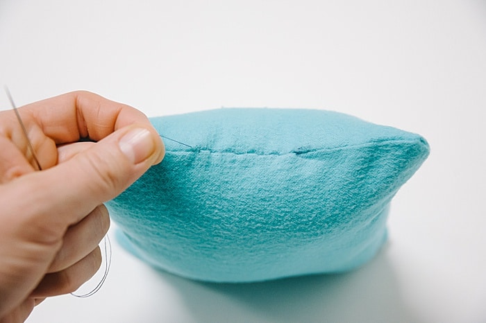 A pillow with a hole that has been closed up with a blind ladder stitch.