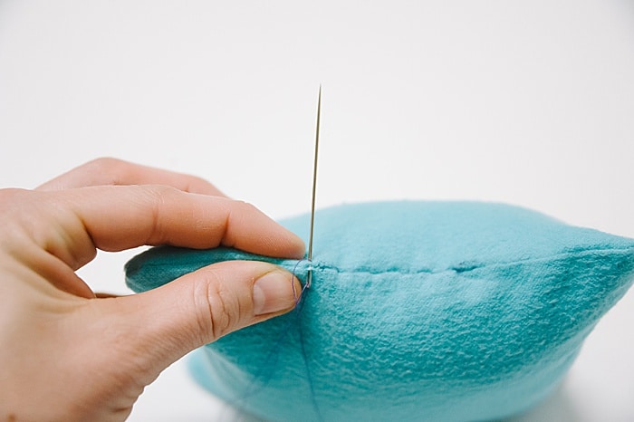 A pillow with a hole that has been closed up with a blind ladder stitch.