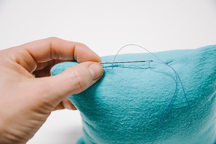 A pillow with a hole that has been closed up with a blind ladder stitch.