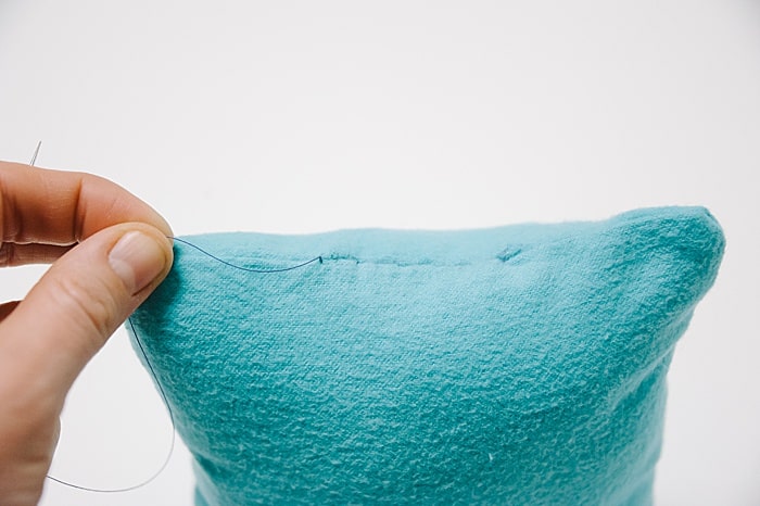 A pillow with a hole that has been closed up with a blind ladder stitch.