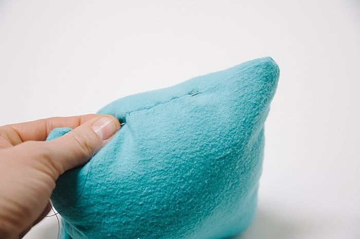 A pillow with a hole that has been closed up with a blind ladder stitch.