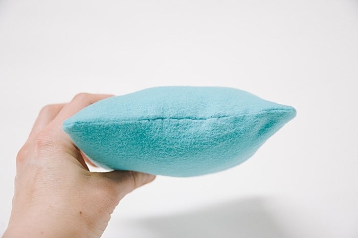 A pillow with a hole that has been closed up with a blind ladder stitch.