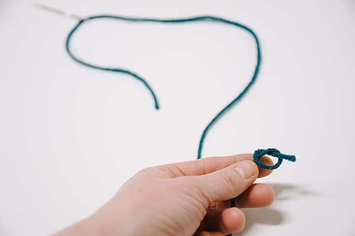 tie a knot in the end of your yarn string, for a single strand thread.