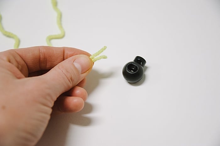 Pass the two ends of your string through a fastener.