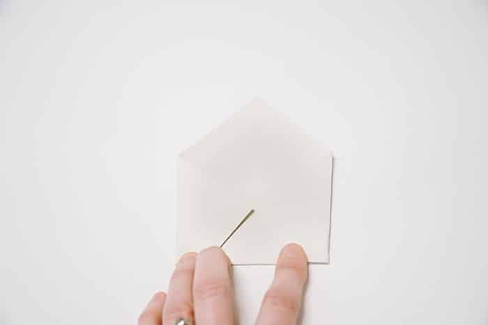 fold the right corner of the paper into the middle and press the edge flat