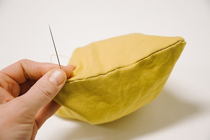 A yellow duck cloth bean bag with the turn hole sewn shut using a blind ladder stitch.