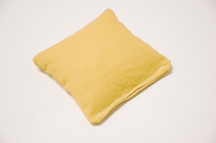 A yellow duck cloth bean bag with the turn hole topstitched clothes.