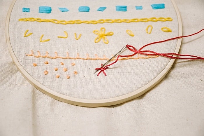 to make a woven wheel embroidery stitch, go over and under each stitch, repeat as the woven wheel rose embroidery stitch forms