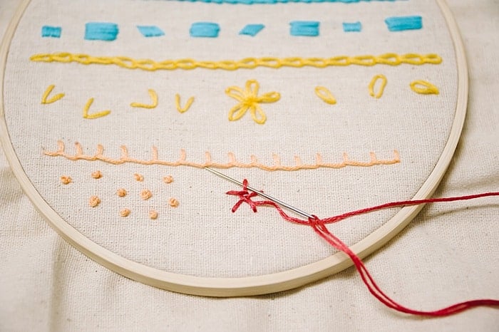 to make a woven wheel embroidery stitch, go over and under each stitch, repeat as the woven wheel rose embroidery stitch forms