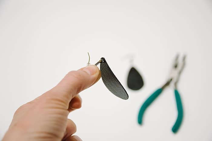 insert metal earring hooks into holes in leather earring shape