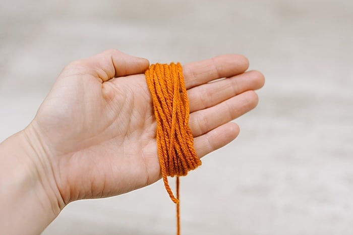 Yarn wrapped around the palm of a hand to make a tassel.