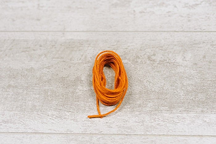 A bundle of yarn being made into a tassel.