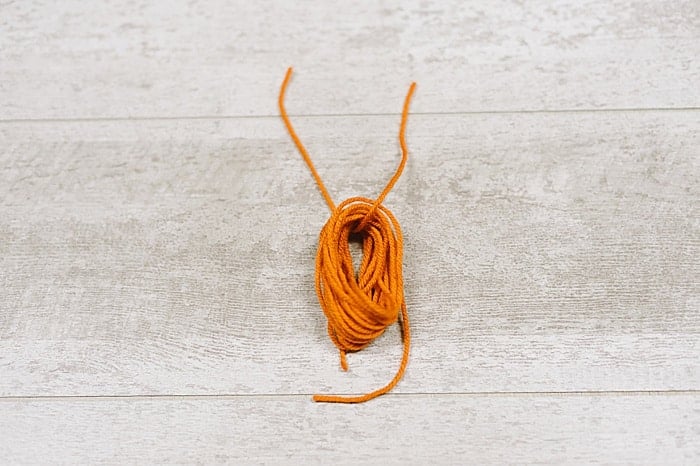 A bundle of yarn being made into a tassel.