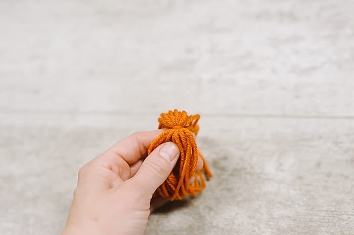 A yarn tassel being made.