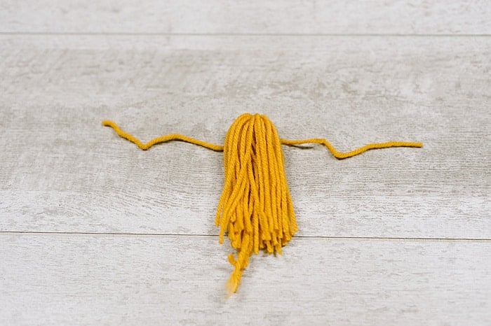 A yarn tassel being assembled.