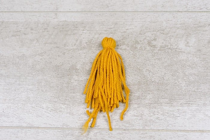 A yarn tassel with uneven bottom edges.