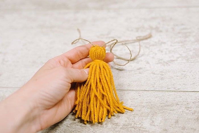 tie a knot in the twine at the top of the tassel