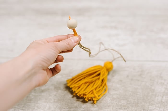add wooden beads to the top of the diy yarn tassel