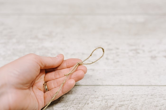 cut a section of twine for your garland, and tie a knot in one end