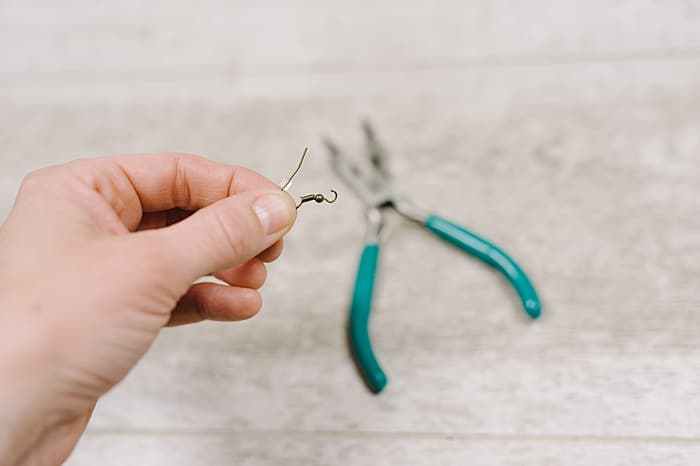 use a pliers to open the ring at the bottom of the earring hook