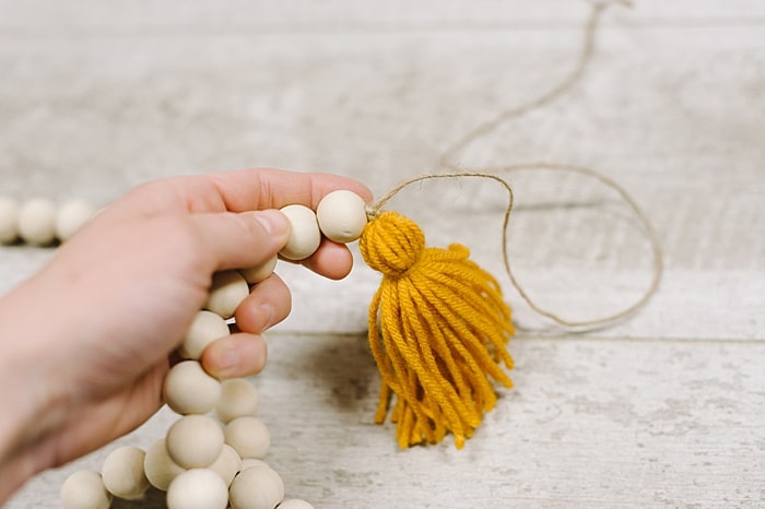 knot the string to attach the tassel to the garland