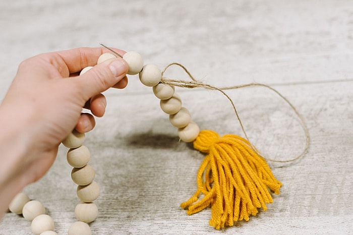 thread needle and twine up through the beads to hide