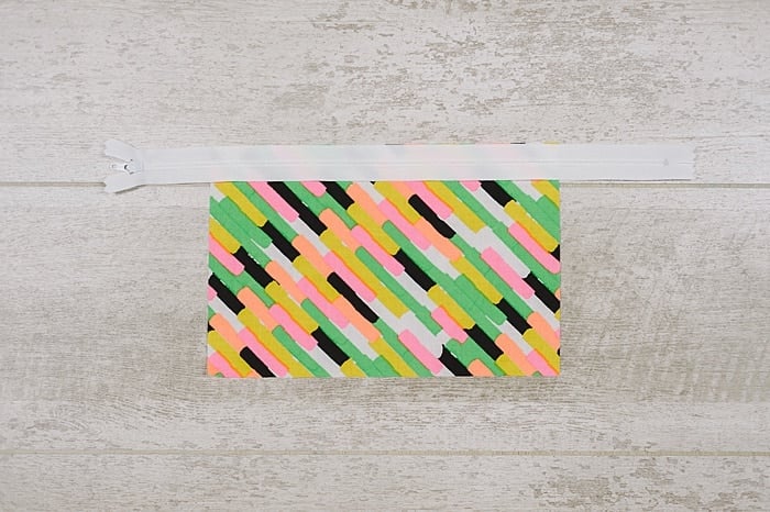 Fabric and zipper being sewn into a zipper pouch.