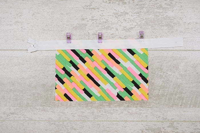 Fabric and zipper being sewn into a zipper pouch.