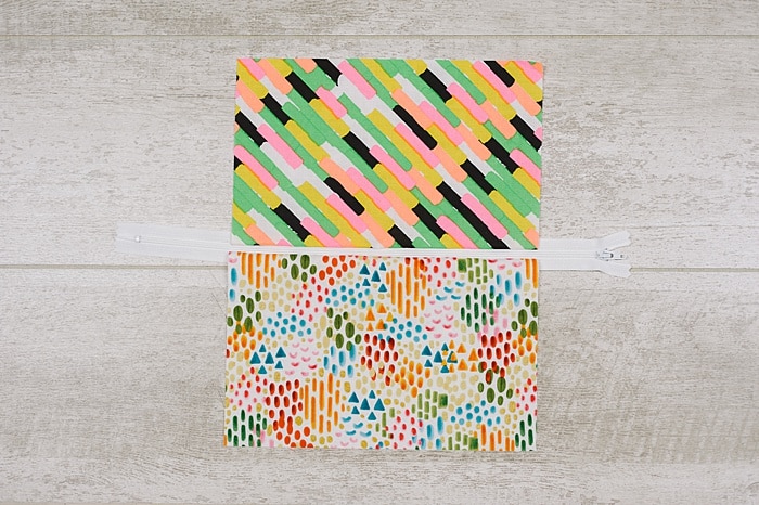 Fabric and zipper being sewn into a zipper pouch.