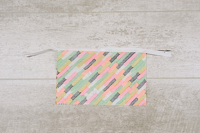 Fabric and zipper being sewn into a zipper pouch.