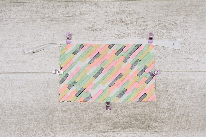 Fabric and zipper being sewn into a zipper pouch.