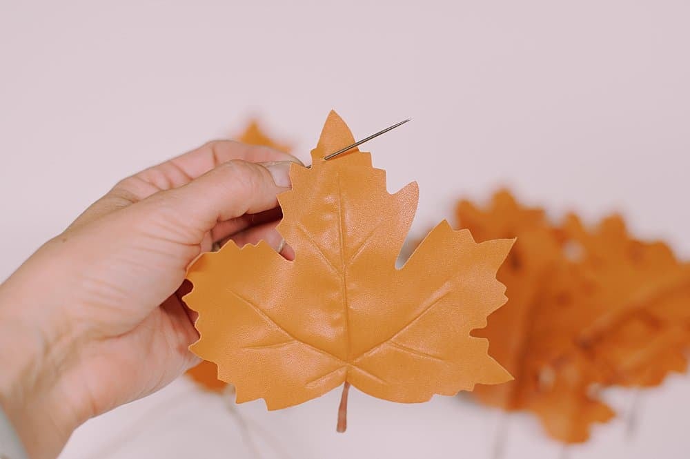 thread the faux leather leaves onto the twine